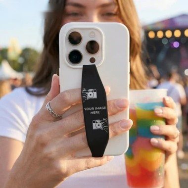 Phone with a custom photo strap held up at a festival