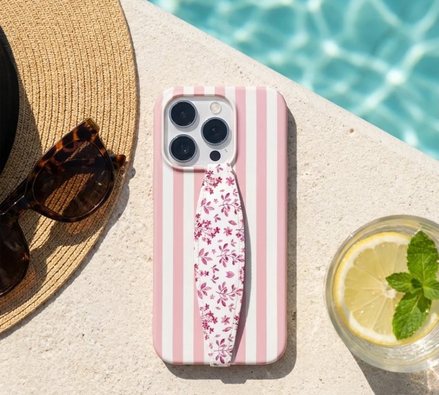 Pink striped case with floral strap by a pool